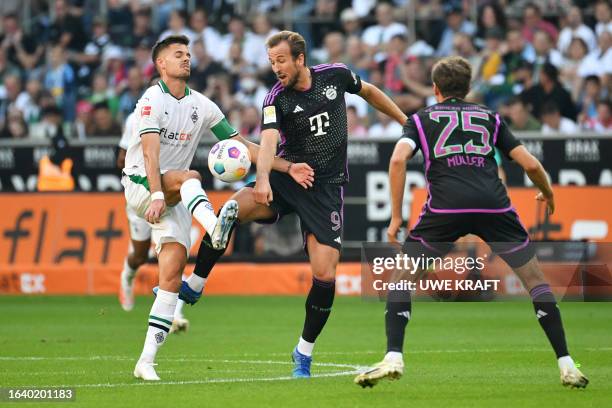 Moenchengladbach's German midfielder Julian Weigl vies for the ball with Bayern Munich's English forward Harry Kane and Bayern Munich's German...