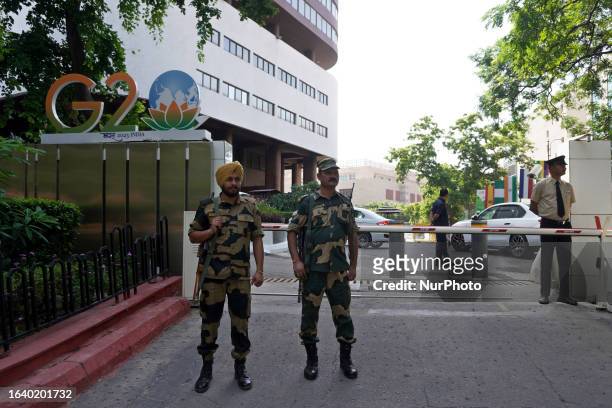 Paramilitary personnel along with security staff stand guard outside the Le Meridien hotel during a rehearsal ahead of the G20 Summit in New Delhi,...