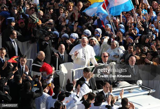 Pope Francis waves to the crowd as he arrives in the Pope Mobile for his Inauguration Mass in St Peter's Square on March 19, 2013 in Vatican City,...