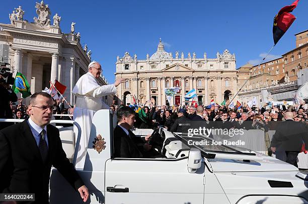 Pope Francis waves to the crowd as he arrives in the Pope Mobile for his Inauguration Mass in St Peter's Square on March 19, 2013 in Vatican City,...