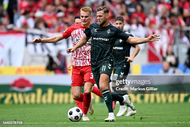 Niclas Fuellkrug of Werder Bremen battles for possession with Philipp Lienhart of Sport-Club Freiburg during the Bundesliga match between Sport-Club...