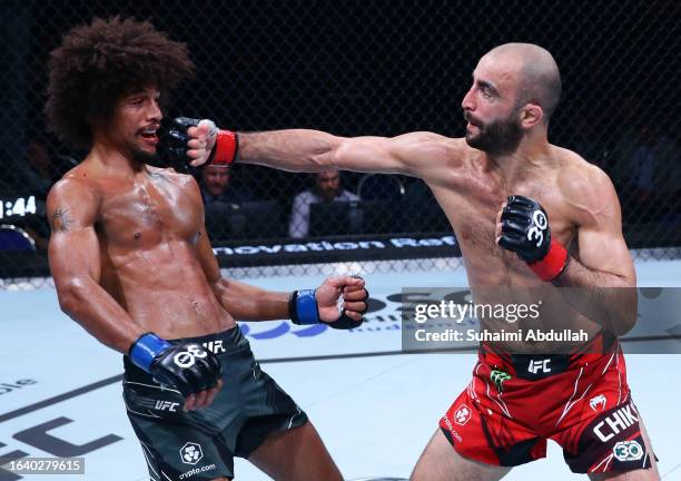 Giga Chikadze of Georgia punches Alex Caceres in a featherweight bout during the UFC Fight Night event at Singapore Indoor Stadium on August 26, 2023...