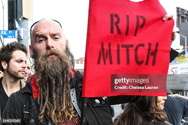 Bassist Chris Kael of Five Finger Death Punch arrives carrying a flag in honor of Mitch Lucker at the 6th annual Rockstar energy drink Mayhem...