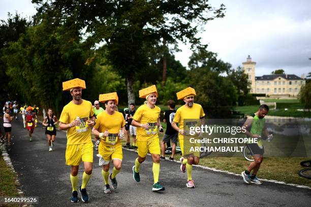 Participants wearing costumes take part in the Medoc marathon near Pauillac, southwestern France, on September 2, 2023. The 37th edition of the...