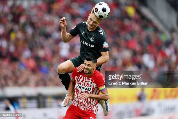 Amos Pieper of Werder Bremen and Vincenzo Grifo of Sport-Club Freiburg battle for a header during the Bundesliga match between Sport-Club Freiburg...