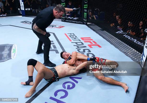 Max Holloway works for a submission against Chan Sung Jung of South Korea in a featherweight bout during the UFC Fight Night event at Singapore...
