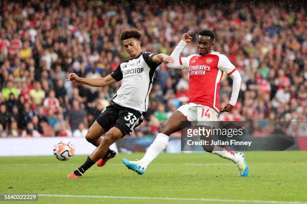 Eddie Nketiah of Arsenal scores the team's second goal whilst under pressure from Antonee Robinson of Fulham during the Premier League match between...