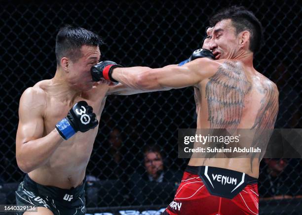 Chan Sung Jung of South Korea and Max Holloway trade punches in a featherweight bout during the UFC Fight Night event at Singapore Indoor Stadium on...