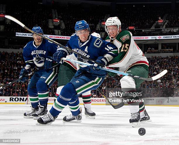 Alexandre Burrows of the Vancouver Canucks and Dany Heatley of the Minnesota Wild battle for the puck during their NHL game at Rogers Arena March 18,...