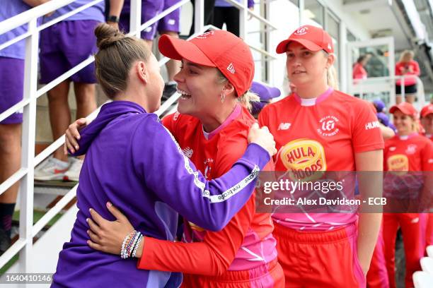 Alex Hartley of Welsh Fire embraces players of Northern Superchargers after the match is abandoned following a Storm and Lightning, resulting in...