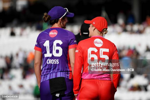 Kate Cross of Northern Superchargers speaks with Alex Hartley of Welsh Fire as they leave the field after the abandonment of the match following a...