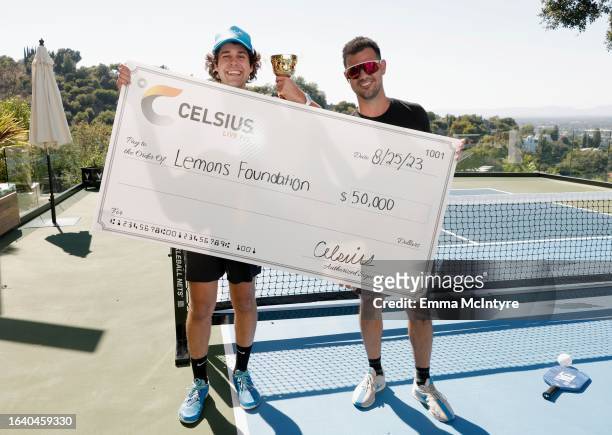 David Dobrik and Taylor Lautner, winners of the CELSIUS pickleball tournament at David Dobrik’s home, pose with the award on August 25, 2023 in...