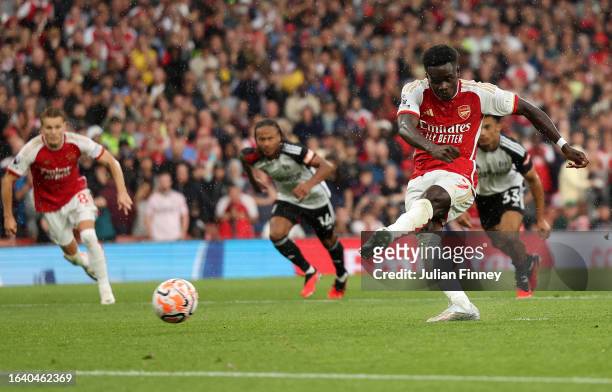 Bukayo Saka of Arsenal scores the team's first goal from a penalty kick during the Premier League match between Arsenal FC and Fulham FC at Emirates...