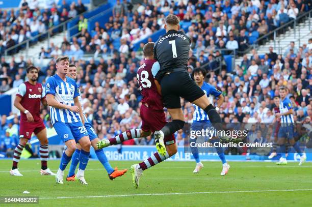 Tomas Soucek of West Ham United and Bart Verbruggen of Brighton & Hove Albion collide as they battle for the ball during the Premier League match...