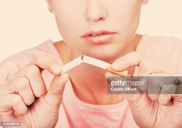 concept non-fumeurs. jeune femme brisant une cigarette - crushed photos et images de collection