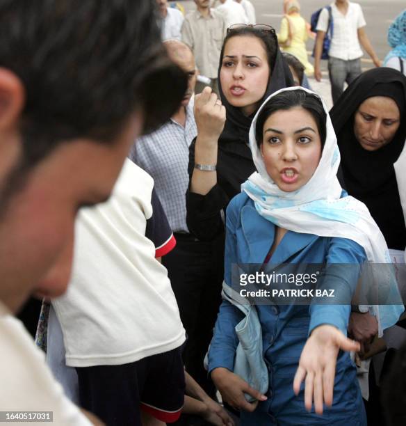 Iranian women gesture as they argue with a conservative man about the veil and women's rights during an electoral campaign gathering for presidential...