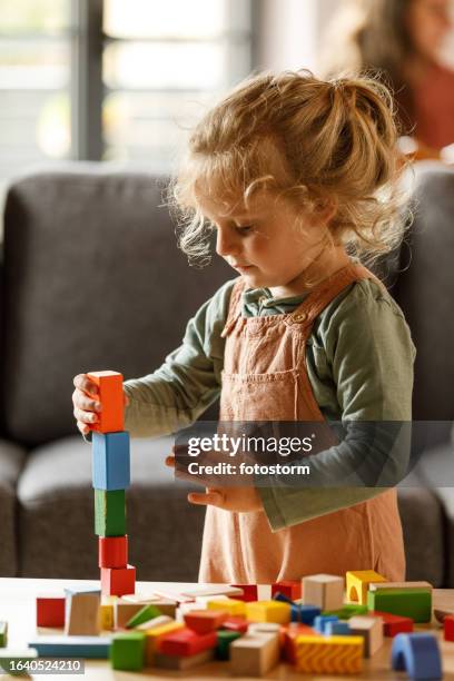 cute toddler playing with colorful wooden blocks - concentration game stock pictures, royalty-free photos & images