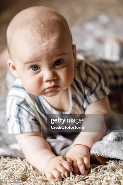 neonato adorabile sdraiato sulla pancia, guardando la macchina fotografica - soltanto un neonato maschio foto e immagini stock