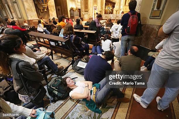 Argentinians sit in Metropolitan Cathedral during an overnight vigil while waiting to watch a live broadcast of the installation of Pope Francis in...