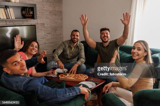 group of people greeting you when arriving to the pizza party with them - the party arrivals stock pictures, royalty-free photos & images