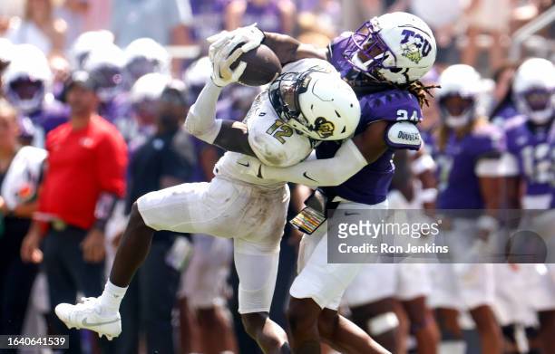 Travis Hunter of the Colorado Buffaloes makes a catch as Avery Helm of the TCU Horned Frogs defends during the second half at Amon G. Carter Stadium...