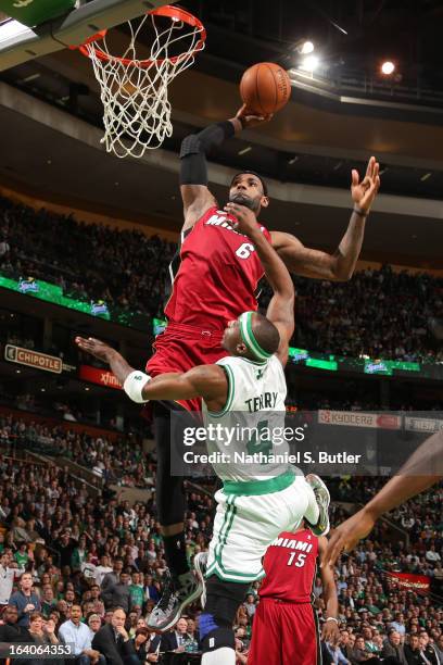 LeBron James of the Miami Heat dunks on an alley-oop pass against Jason Terry of the Boston Celtics on March 18, 2013 at TD Garden in Boston,...