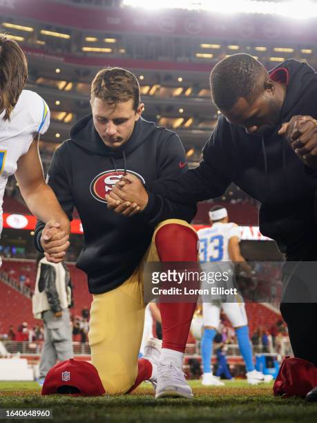 Brock Purdy of the San Francisco 49ers prays with fellow players and coaches following a preseason game against the Los Angeles Chargers at Levi's...
