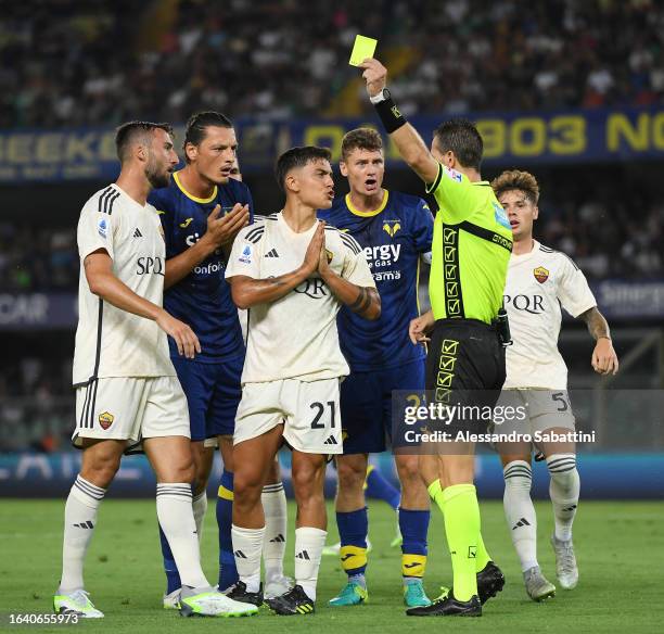 Paulo Dybala of AS Roma is shown a yellow card by Referee Daniele Doveri during the Serie A TIM match between Hellas Verona FC and AS Roma at Stadio...