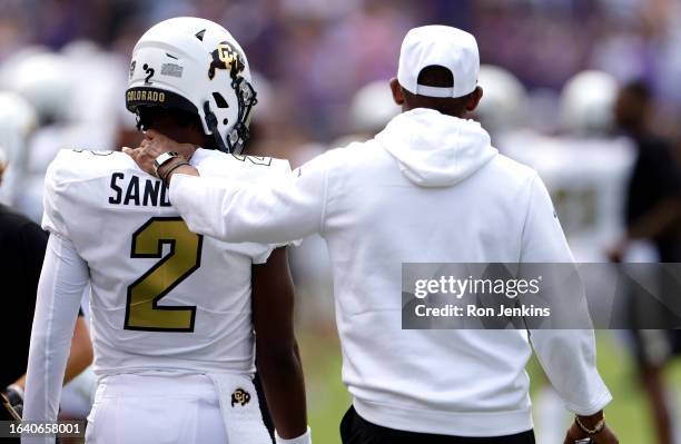 Shedeur Sanders of the Colorado Buffaloes and his father and head coach Deion Sanders walk the sidelines just before the game against the TCU Horned...