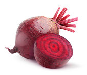 Whole beetroot next to one cut in half on a white background