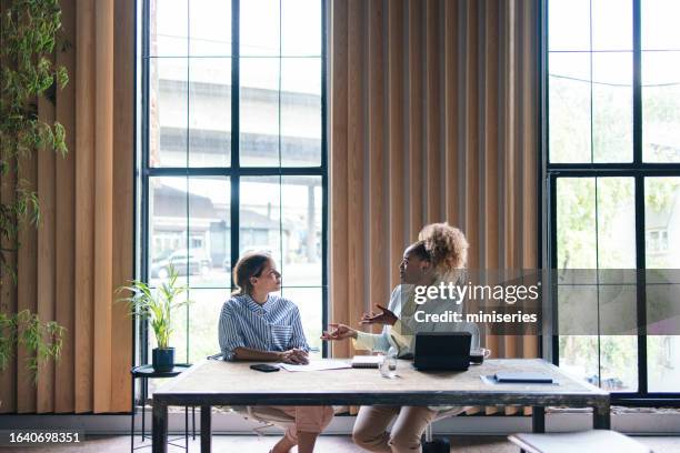 two successful businesswomen having a meeting at the office - coach stock pictures, royalty-free photos & images