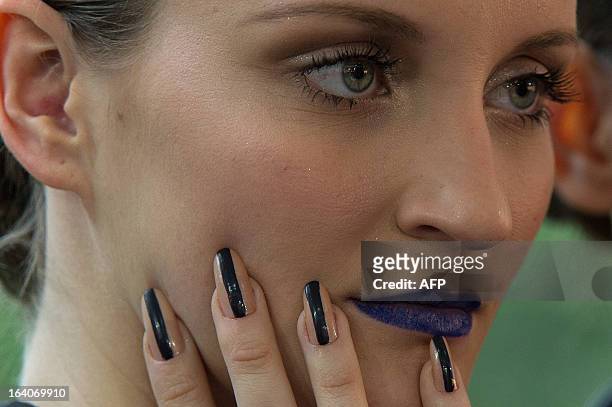 Model has make-up applied before presenting a creation by Acquastudio for Esther Bauman during the 2013 Summer collections of the Sao Paulo Fashion...