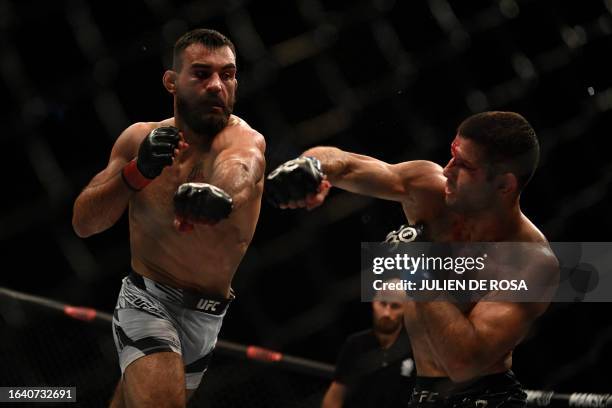 Brazilian mixed martial arts fighter Thiago Moises fights against French mixed martial arts fighter Benoit Saint Denis on the octogone during their...