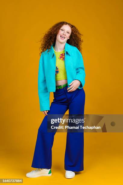 girl wearing jacket and flare pants on plain background - pantaloni a zampa di elefante foto e immagini stock