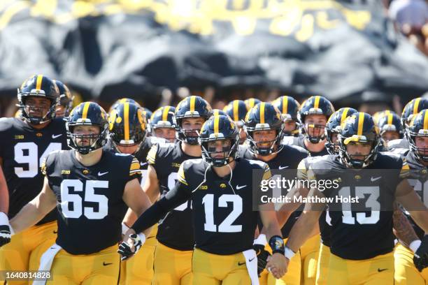 Quarterback Cade McNamara of the Iowa Hawkeyes leads the team onto the field before the first half against the Utah State Aggies at Kinnick Stadium...