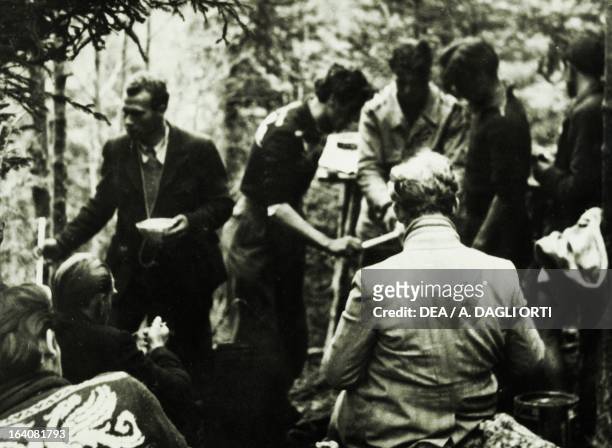 Meal time for a partisan unit in the underbrush of the woods on the Plateau of the Seven Communities . World War II, Resistance, Italy, 20th century....