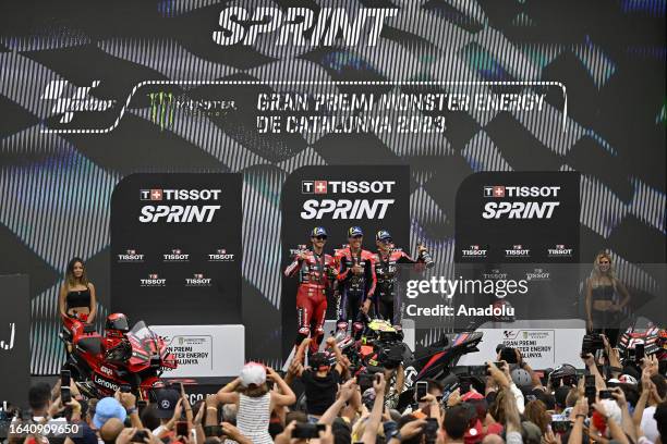 Aprilia's Spanish rider Aleix Espargaro celebrates on the podium with second place winner Francesco Bagnaia of Ducati team and third placed Maverick...