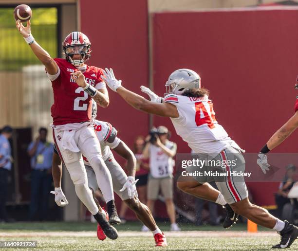 Tayven Jackson of the Indiana Hoosiers throws the under pressure from JT Tuimoloau of the Ohio State Buckeyes during the second half at Memorial...