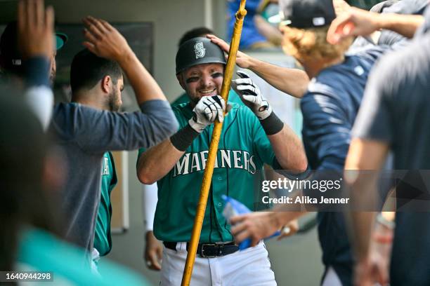 Cal Raleigh of the Seattle Mariners celebrates with teammates after hitting a solo home run during the sixth inning against the Kansas City Royals at...