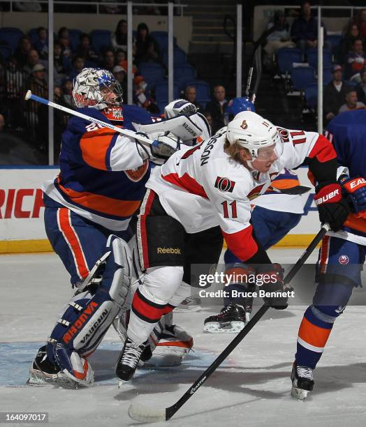 Evgeni Nabokov of the New York Islanders hits Daniel Alfredsson of the Ottawa Senators during thefirst period at the Nassau Veterans Memorial...