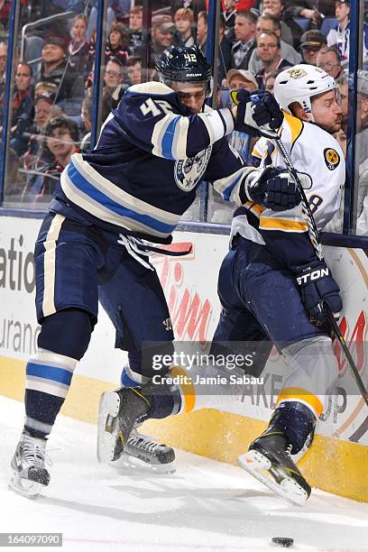 Artem Anisimov of the Columbus Blue Jackets checks Kevin Klein of the Nashville Predators into the boards during the first period on March 19, 2013...