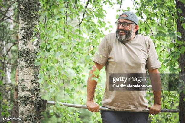 reifer erwachsener mann, der im freien sport treibt - reck stock-fotos und bilder