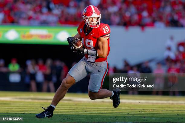 Brock Bowers of the Georgia Bulldogs looks for extra yardage after the reception during the second quarter against the Tennessee Martin Skyhawks at...