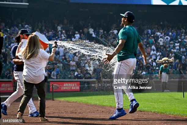 Eugenio Suarez of the Seattle Mariners gives Julio Rodriguez a sports drink shower after the game against the Kansas City Royals at T-Mobile Park on...