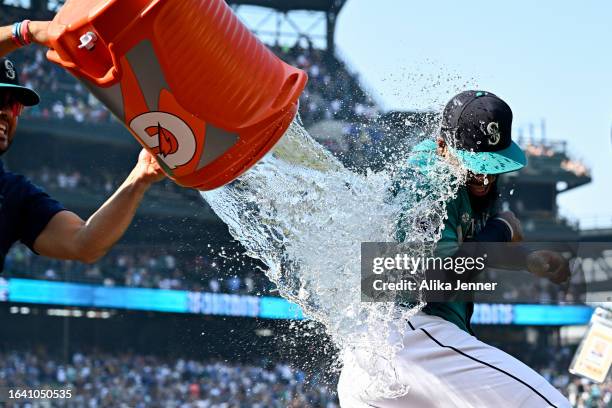 Eugenio Suarez of the Seattle Mariners gives Teoscar Hernandez a sports drink shower after the game against the Kansas City Royals at T-Mobile Park...