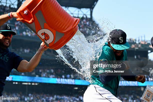 Eugenio Suarez of the Seattle Mariners gives Teoscar Hernandez a sports drink shower after the game against the Kansas City Royals at T-Mobile Park...