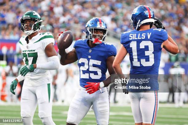 Jashaun Corbin of the New York Giants celebrates his second quarter rushing touchdown with David Sills V against the New York Jets during a preseason...
