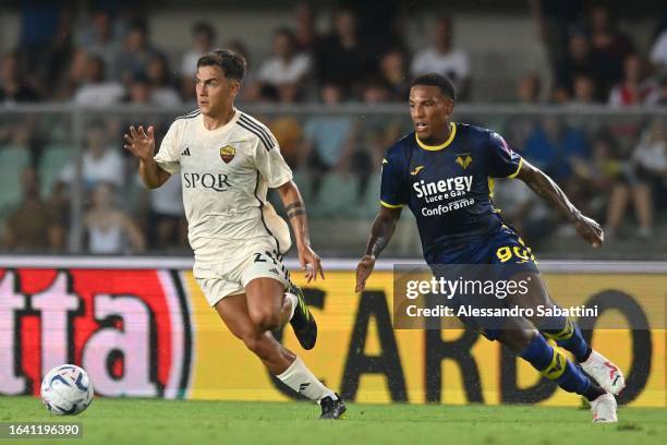 Paulo Dybala of AS Roma competes for the ball with Michael Folorunsho of Hellas Veronaduring the Serie A TIM match between Hellas Verona FC and AS...