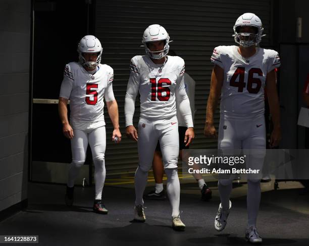 Matt Prater, Nolan Cooney and Aaron Brewer of the Arizona Cardinals walk out of the visitors tunnel before the preseason game against the Minnesota...