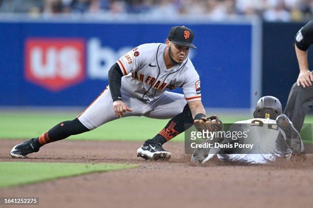 Jose Azocar of the San Diego Padres is tagged out by Thairo Estrada of the San Francisco Giants as the tries to steal second base during the fifth...